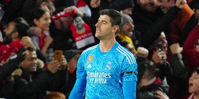 Real Madrid's goalkeeper Thibaut Courtois, right, gestures after Liverpool's Mohamed Salah scores his side's second goal during the Champions League, round of 16, first leg soccer match between Liverpool and Real Madrid at the Anfield stadium in Liverpool, England, Tuesday, Feb. 21, 2023.