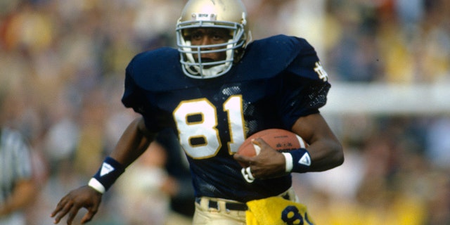 Tim Brown de Notre Dame Fighting Irish corre con el balón durante un juego alrededor de 1986 en el estadio de Notre Dame en South Bend, Indiana.