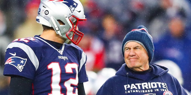 Tom Brady, #12, talks to New England Patriots head coach Bill Belichick, right, before a game against the Dallas Cowboys at Gillette Stadium on Nov. 24, 2019 in Foxborough, Massachusetts.