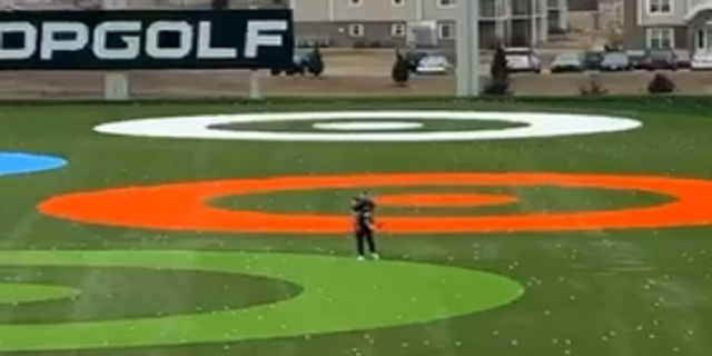 The child is eventually caught farther down the Topgolf driving range.