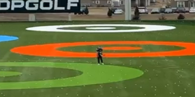 The child is eventually caught farther down the Topgolf driving range.