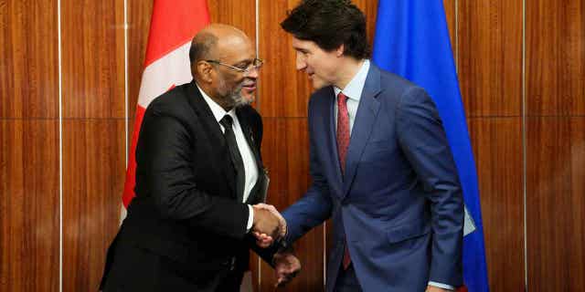 Prime Minister Justin Trudeau, right, shakes hands with the prime minister of Haiti in Nassau, Bahamas, on Feb. 16, 2023.