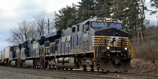 A Norfolk Southern freight train pulled by locomotive 7565, a GE ES44DC Evolution Series diesel locomotive, travels east.  On railroad tracks running parallel to Penn Avenue on the 2:00 pm block, Wednesday morning, January 27, 2021