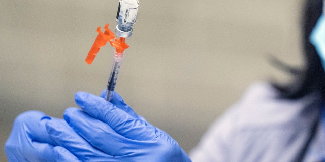 Los Angeles County Department of Public Health Nurse Eliane McGhee prepares COVID-19 booster shot during the Los Angeles Comic Con at the Los Angeles Convention Center, Dec 2, 2022. 