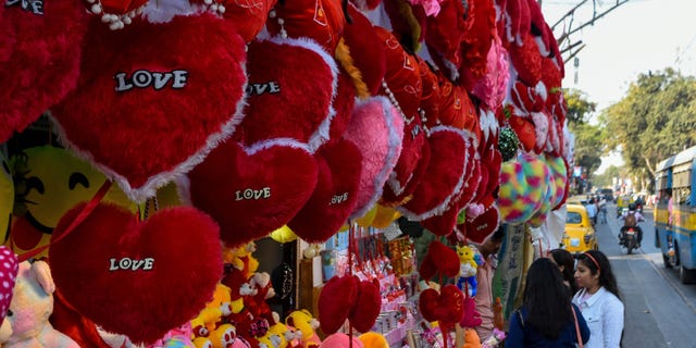 People as seen in front of a gift shop decorated with items for sale for Valentine's Day, as seen in Kolkata, India, on Feb. 13, 2023.