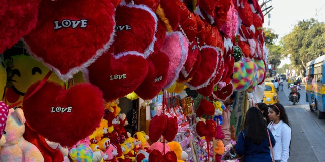 People as seen in front of a gift shop decorated with items for sale for Valentine's Day, as seen in Kolkata, India, on Feb. 13, 2023.