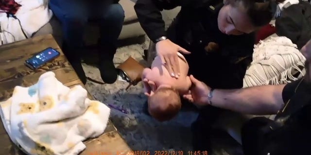 L'agent Alexis Callaway administre une technique de sauvetage à un bébé qui s'étouffe en Géorgie.