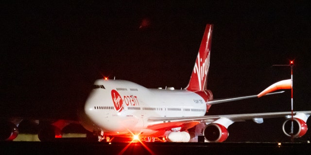 Pemandangan umum dari Cosmic Girl, pesawat Boeing 747 yang digunakan ulang membawa roket LauncherOne di bawah sayap kirinya, saat persiapan akhir dilakukan di Bandara Cornwall Newquay pada 9 Januari 2023, di Newquay, Inggris Raya.