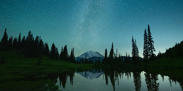 NatGeo photo contest honorable mention: At about 3:40 a.m. on a frigid summer morning, photographer W. Kent Williamson snapped this image from Tipsoo Lake in Mount Rainier National Park, Washington. From across the still water, he could see a line of headlights as weary climbers approached the peak’s 14,411-foot summit — the culmination of a multi-day climb. 