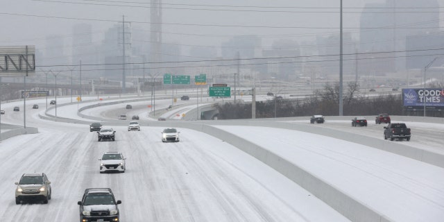 Cars drive down an icy highway as cold weather moves through Dallas, Texas, U.S., January 31, 2023.