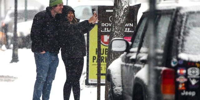 A couple takes a snowy selfie in downtown Flagstaff, Ariz., Tuesday afternoon, Feb. 14, 2023. 