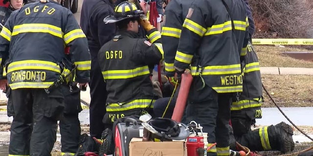 Firefighters at the scene where Westmont Public Works employee Matt Heiden became trapped in an underground vault before he died Thursday.