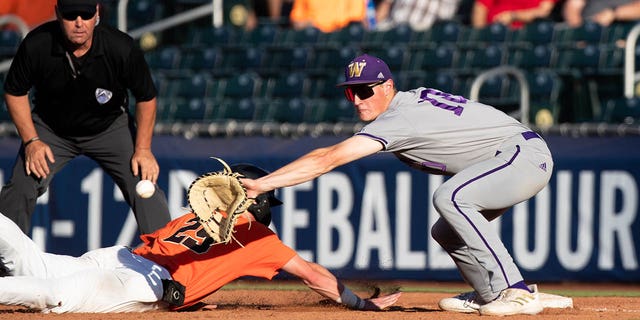 The Oregon State Beavers' Jacob Melton (29) reaches for first base as Washington Huskies infielder Will Simpson (10) misses a throw during a PAC-12 baseball tournament May 25, 2022, at Scottsdale Stadium in Scottsdale, Ariz.