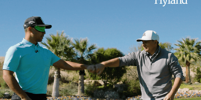 Xander Schauffele fists-bumps his coach after completing one of the challenges.