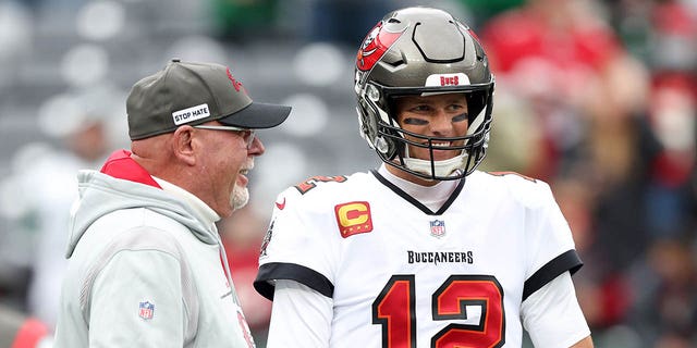 Tom Brady (12) of the Tampa Bay Buccaneers and head coach Bruce Arians talk during warmups prior to a game against the New York Jets at MetLife Stadium Jan. 2, 2022, in East Rutherford, N.J. 