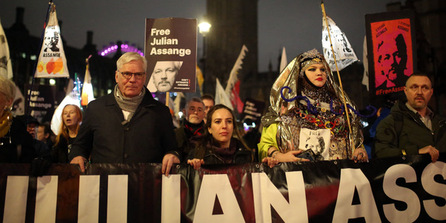 Supporters of Julian Assange walk during a 'Night Carnival for Assange' march in London.