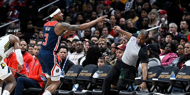 Bradley Beal #3 of the Washington Wizards crashes into referee John Butler #30 in the third quarter against the Indiana Pacers at Capital One Arena on February 11, 2023 in Washington, DC.  
