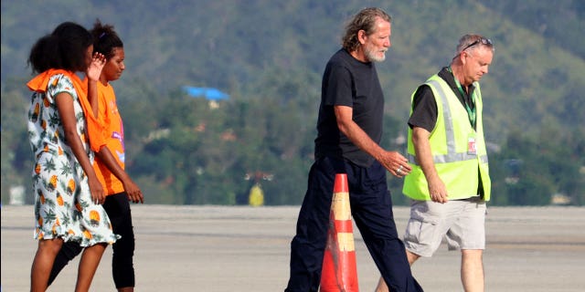 Bryce Barker, second to the right, who was held hostage for a week in Papua New Guinea by an armed group, is being escorted from a plane following his release on Feb. 26, 2023.