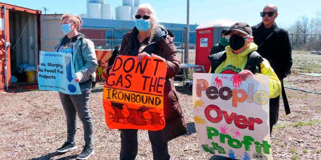 New Jersey activists attend a protest against a proposed backup power plant for a sewage treatment facility in Newark on April 20, 2022.