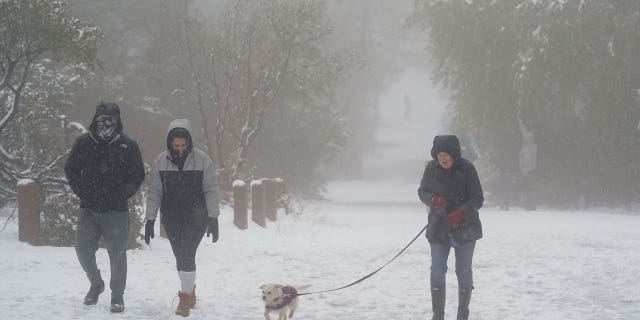 Pedestrians in Walnut Creek, California, navigate snowy conditions that have repeated themselves nationwide this week.
