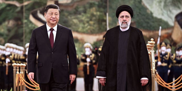 Visiting Iranian President Ebrahim Raisi, right, walks with Chinese President Xi Jinping during a welcome ceremony in Beijing, on Feb. 14, 2023.
