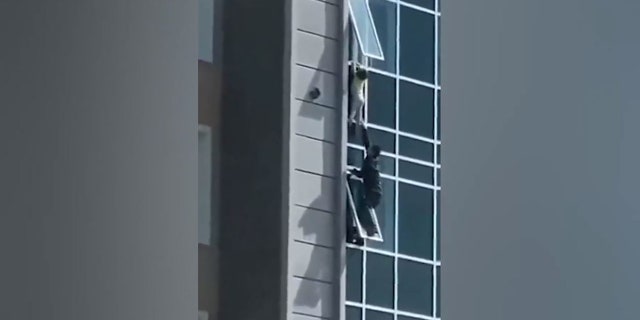 Un buen samaritano en China trepa por una ventana para salvar a un niño que cuelga de una construcción 4 El buen samaritano salió por la ventana sin cuerdas ni arneses.