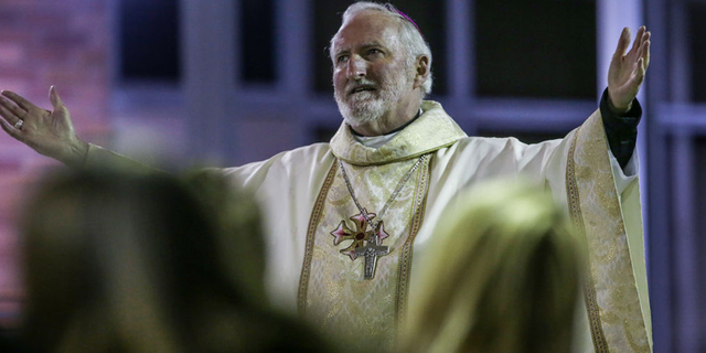 Bishop David O'Connell of St. Cornelius Catholic Church hosts a community memorial service.