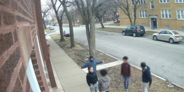 An off-duty Chicago police officer approaches four individuals who were arguing outside to diffuse the argument.