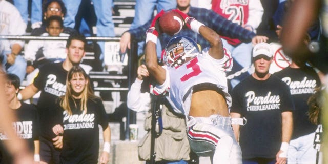El receptor abierto Dimitrious Stanley de los Ohio State Buckeyes se enfoca en el balón mientras deja sus pies para hacer una recepción lateral durante la victoria de los Buckeyes por 42-14 sobre los Purdue Boilermakers en el Ohio Stadium en Columbus, Ohio.