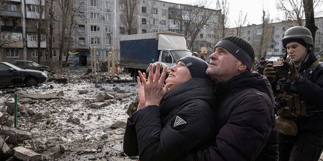 A woman reacts to her brother being rescued after an apartment building was heavily damaged by a missile strike in Ukraine on Feb. 15, 2023. 