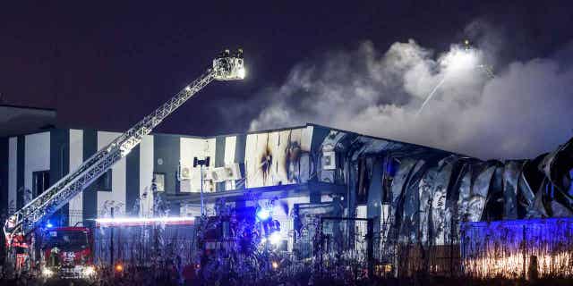 Firefighters extinguish a fire at a drone factory in Marupe, Latvia, on Feb. 7, 2023.
