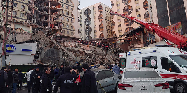 Rescue workers and medical teams try to reach trapped residents in a collapsed building following an earthquake in Diyarbakir, southeastern Turkey.