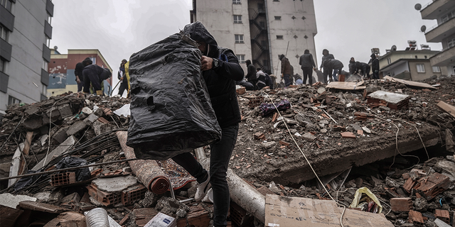 People and emergency teams search for people in the rubble in a destroyed building in Gaziantep, Turkey, Monday, Feb. 6, 2023.