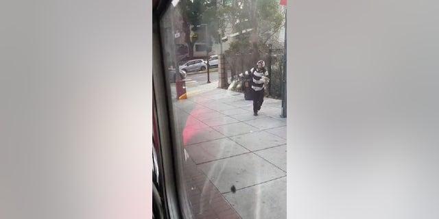 A man is seen throwing an egg at a San Francisco bus last week.