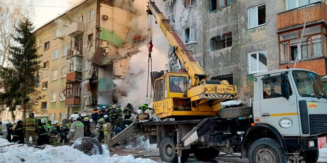 Emergency service employees work at a site of a five-story residential building collapsed after the gas explosion in the Siberian city of Novosibirsk, Russia, on Feb. 9, 2023.