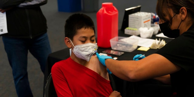 FILE - Johnny Thai, 11, receives the Pfizer COVID-19 vaccine at a pediatric vaccine clinic for children ages 5 to 11 set up at Willard Intermediate School in Santa Ana, California, Nov. 9, 2021.