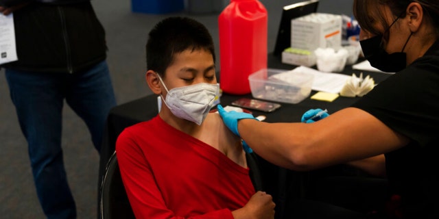 FILE - Johnny Thai, 11, receives the Pfizer COVID-19 vaccine at a pediatric vaccine clinic for children ages 5 to 11 set up at Willard Intermediate School in Santa Ana, California, Nov. 9, 2021.