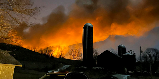 A train fire is seen from a farm in East Palestine, Ohio.