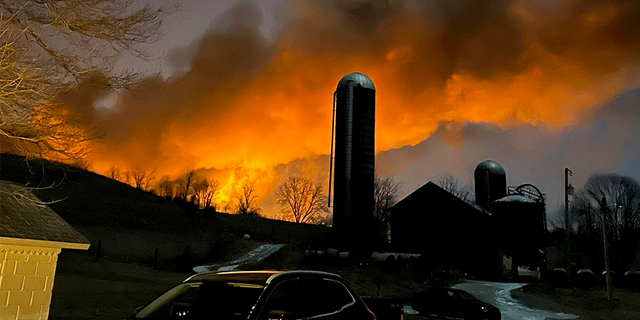 A train fire is seen from a farm in East Palestine, Ohio.