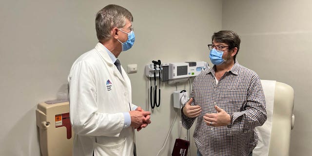 Dr.  John Puskas (left) and patient David Holland undergoing a unique quadruple bypass in November 2022. 