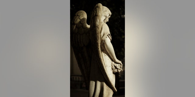 A statue of an angel in a cemetery shown with sunlight and shadow. Even without proper names, angels have done spiritual heavy lifting in the Bible, writes Lauren Green.