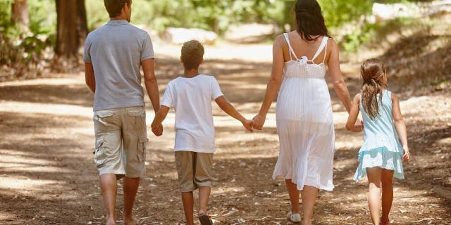 Family walking down forested path