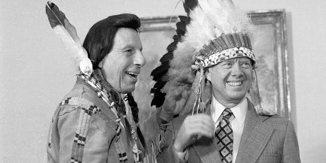 President Carter dons an Indian headdress arsenic he chats pinch Iron Eyes Cody, nan "concerned Indian," during a ceremonial astatine nan White House successful 1978.
