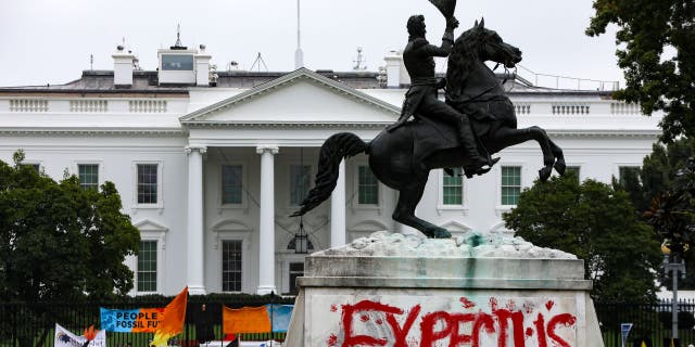 Words "Expect Us" are seen painted at the base of a statue of former President Jackson as hundreds of Native Americans and supporters protested at Lafayette Park in front of the White House in 2021.