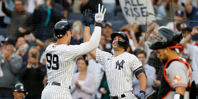 Aaron Judge (99) of the New York Yankees celebrates a home run during the first inning against the Baltimore Orioles with teammate Giancarlo Stanton at Yankee Stadium on May 23, 2022 in New York City. 