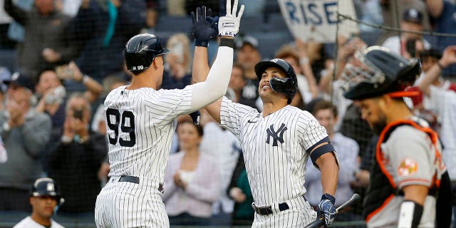 Aaron Judge (99) of the New York Yankees celebrates a home run during the first inning against the Baltimore Orioles with teammate Giancarlo Stanton at Yankee Stadium on May 23, 2022 in New York City. 