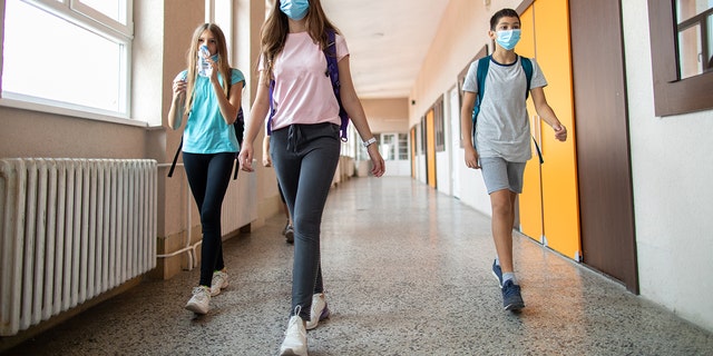 students walking in school with masks