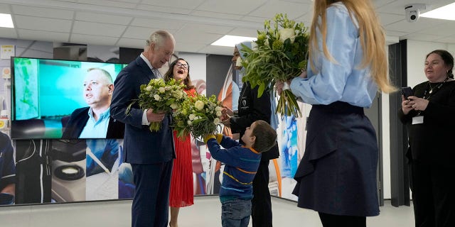 King Charles III was surprised by a 4-year-old who interrupted his conversation with a student at the University of East London Wednesday to give him flowers.