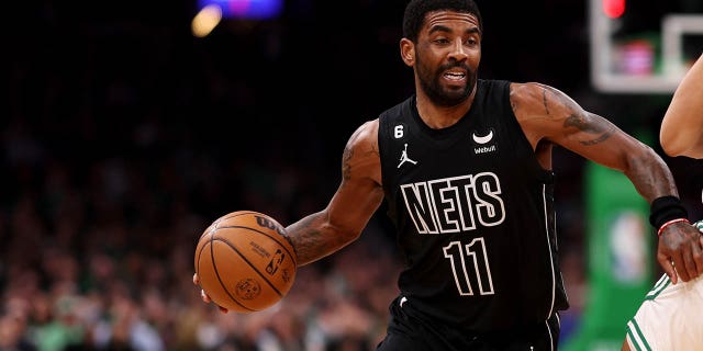 Kyrie Irving of the Brooklyn Nets dribbles past Malcolm Brogdon of the Boston Celtics during the first half at TD Garden Feb. 1, 2023, in Boston.