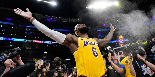 El alero de Los Angeles Lakers, LeBron James, lanza un poco de polvo al aire antes del partido de baloncesto de la NBA del equipo contra el Oklahoma City Thunder el martes, 7 de febrero de 2023, en Los Ángeles.